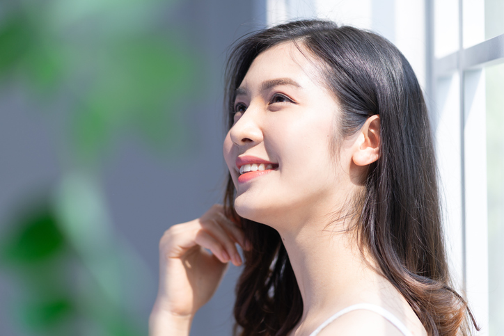 髪をさわる笑顔の女性