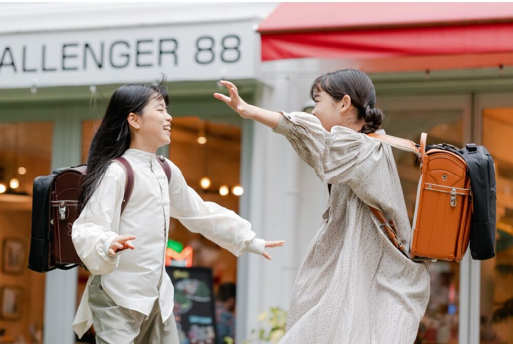 補助バッグをランドセルにつけた女の子たち