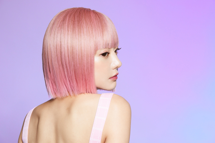 ピンクのヘアカラーで振り返る女性
