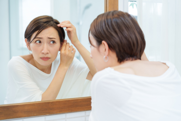 髪を鏡でみる女性