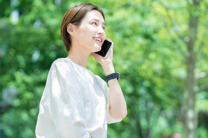 緑の中で笑顔で話す女性
