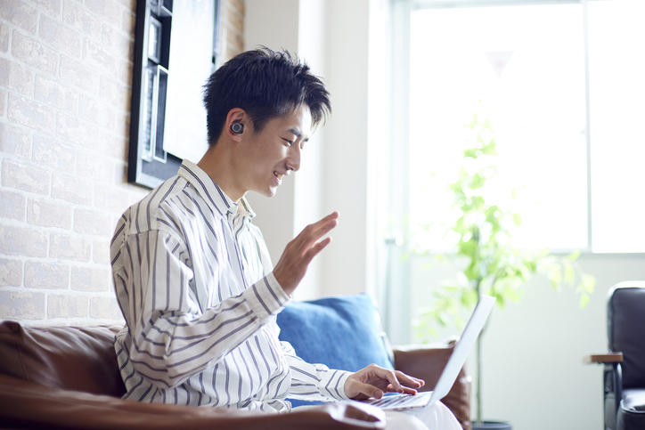 イヤホンをしながら、ネットで会話をする男性