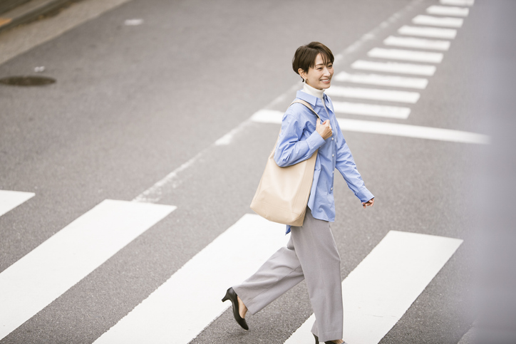 道路を笑顔で歩く女性