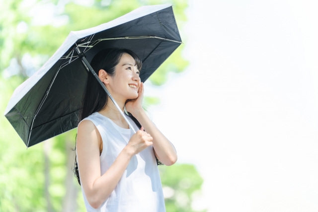 完全遮光日傘を持つ若い女性