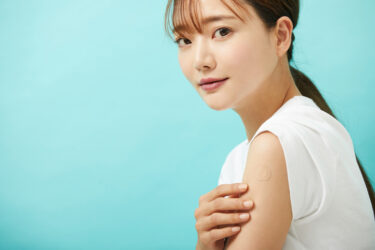 腕のタトゥーにシールを貼った女性