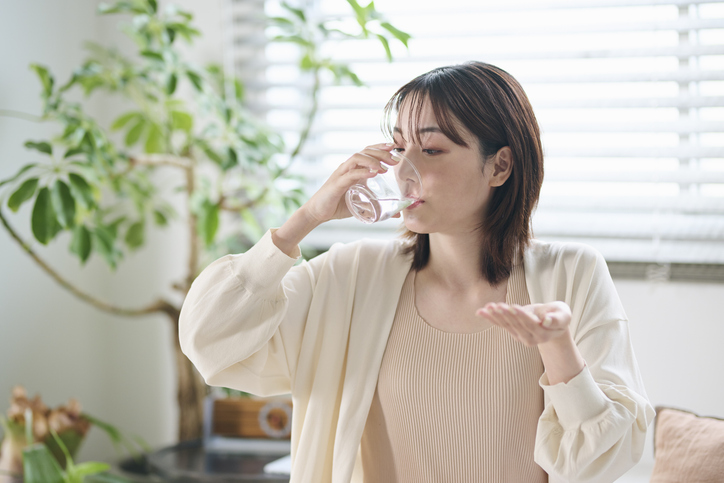 サプリメントを飲む女性