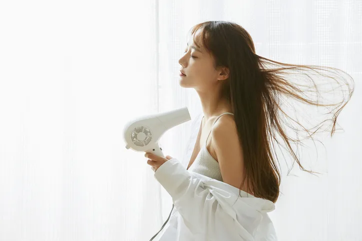 ドライヤーで髪を乾かす日本女性