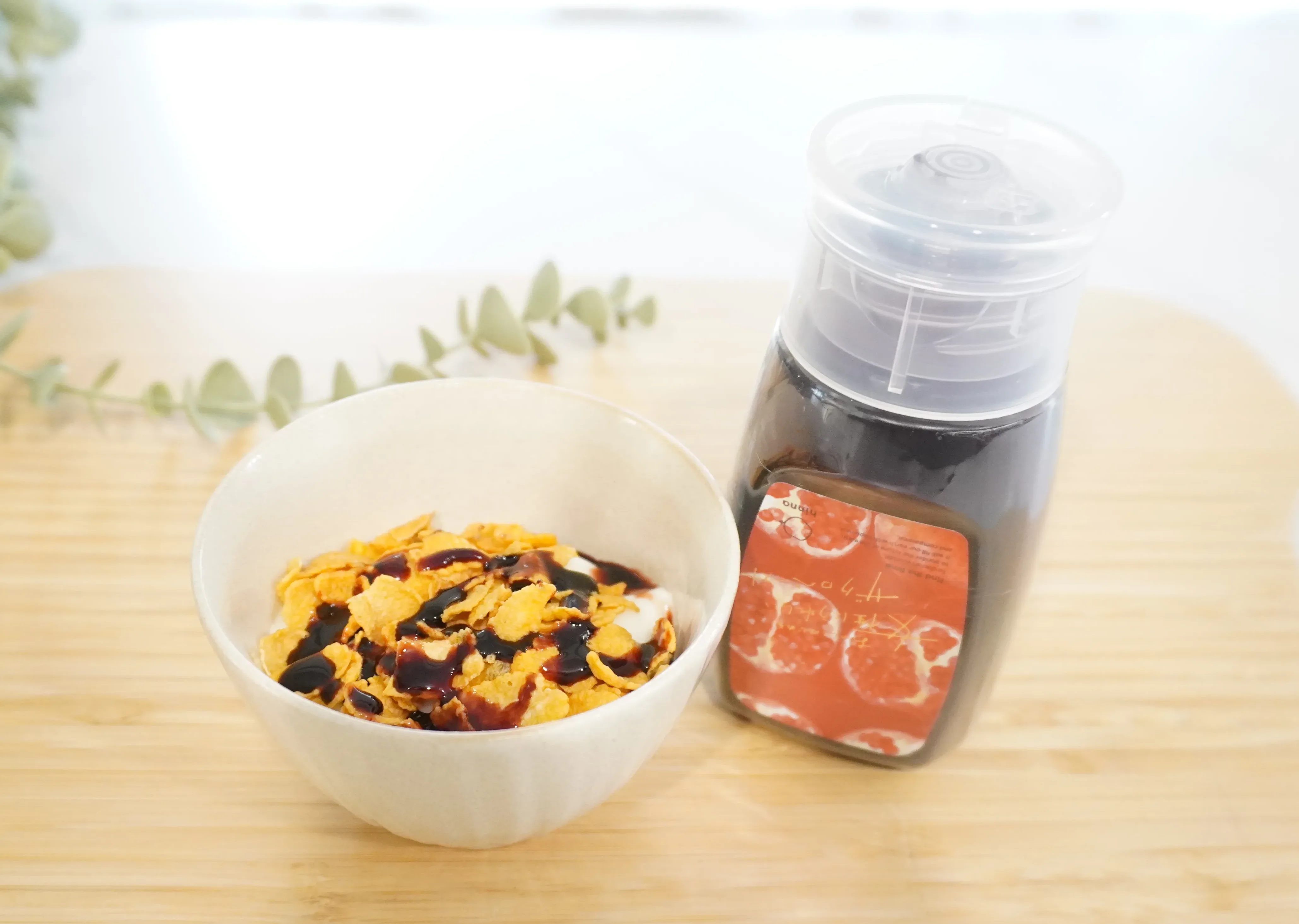 ヨーグルトとコーンフレークにザクロペーストをかけたもの