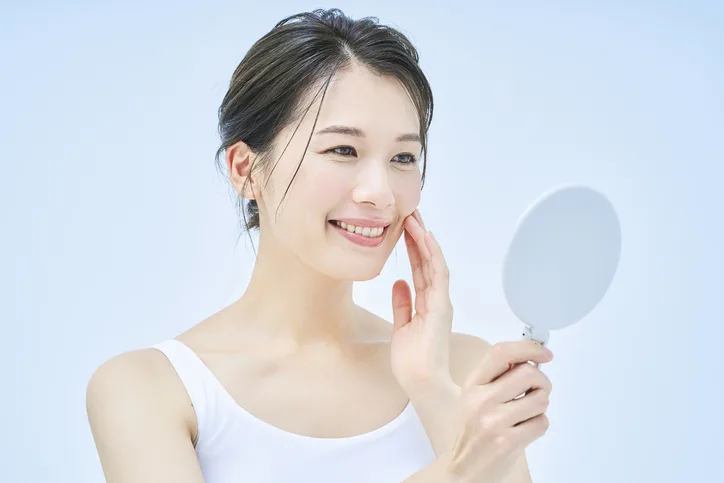 グリセリンフリー下地塗布で鏡を見る女性