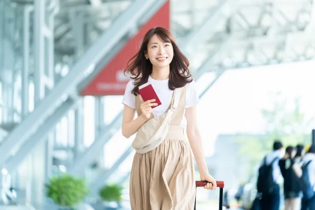 スーツケースを持つ笑顔の女性