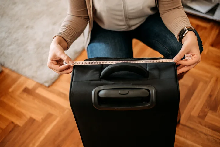 スーツケースのサイズを計る女性