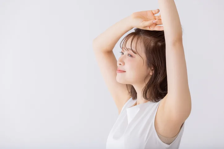 手をあげるブラトップを着た女性